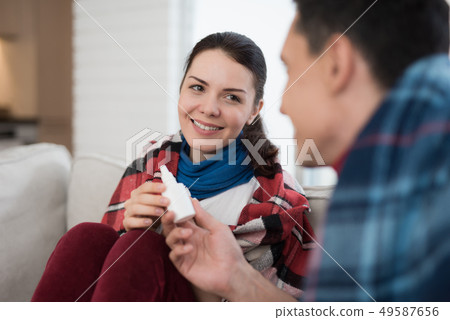 Sick Couple Sitting on Sofa in Checkered Blankets. Sick Couple Sitting on Sofa in Checkered Blankets. 49587656