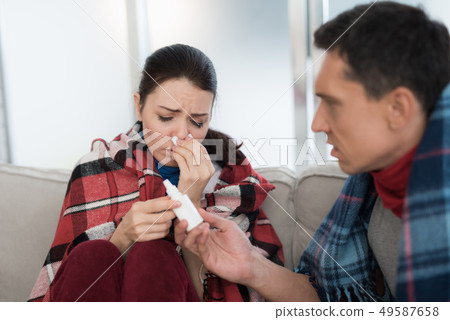Sick Couple Sitting on Sofa in Checkered Blankets. Sick Couple Sitting on Sofa in Checkered Blankets. 49587658