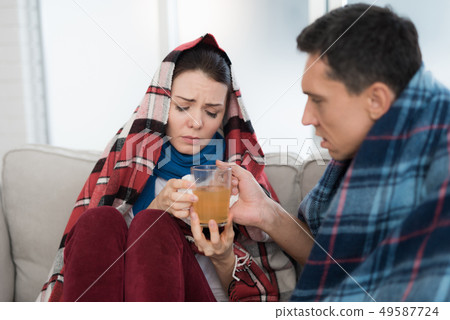 Sick Couple Sitting on Sofa in Checkered Blankets. Sick Couple Sitting on Sofa in Checkered Blankets. 49587724