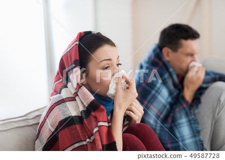 Sick Couple Sitting on Sofa in Checkered Blankets. 49587728