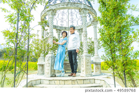 Senior couple at wedding bell on wedding anniversary Senior couple at wedding bell on wedding anniversary 49589768