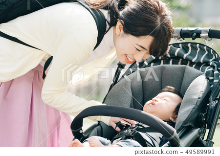 Mother raising baby in stroller strolling 49589991