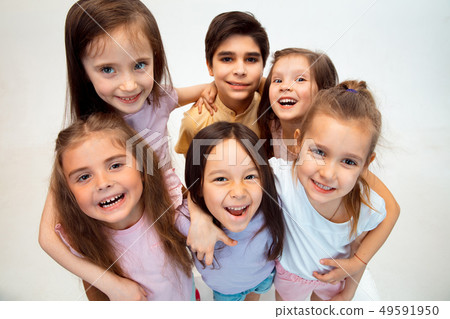 The portrait of cute little boy and girls in stylish clothes looking at camera at studio 49591950