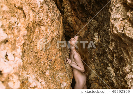 Young naked girl with closed eyes posing in cleft 49592509