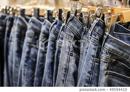 Row of hanged blue jeans pants in shop Row of hanged blue jeans pants in shop 49594410