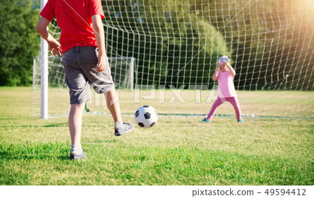Boys playing football on the field with gates 49594412