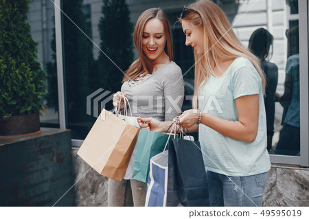 Cute girls with shopping bag in a city Cute girls with shopping bag in a city 49595019