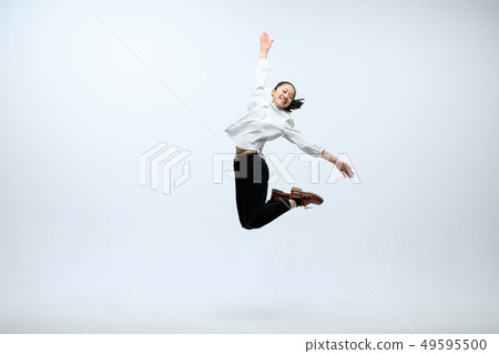 Woman working at office and jumping isolated on studio background 49595500