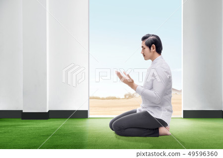 Asian man sitting in praying position Asian man sitting in praying position 49596360