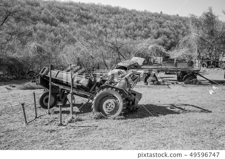 Old rusty abandoned machinery in grass field 49596747