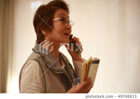 Senior woman talking with a passbook Senior woman talking with a passbook 49598813