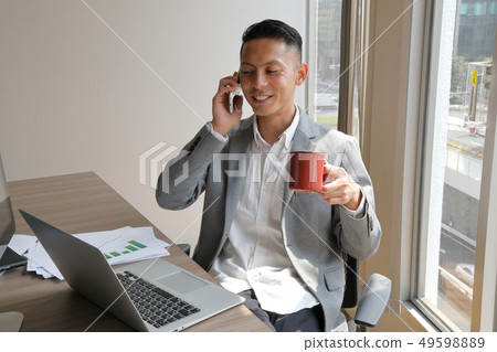 Smiling businessman holding a cup and smiling 49598889