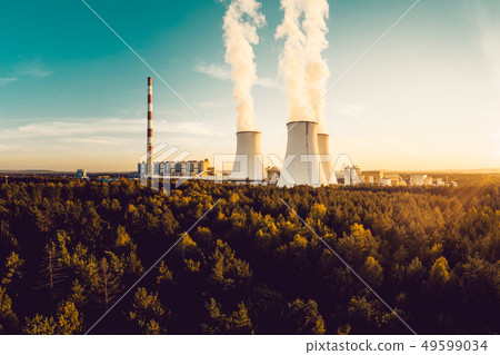 A Power plant with white smoke over it's chimneys A Power plant with white smoke over it's chimneys 49599034