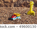 Children's toy truck with gravel or sand. Yellow scoop on the background. Concept of transportation 49600130