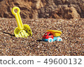 Children's toy truck with gravel or sand. Yellow scoop on the background. Concept of transportation 49600132