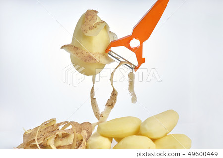 Peeled raw potatoes, peeling potatoes and a peeler 49600449