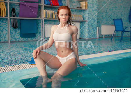 Beautiful young woman in the indoor swimming pool. 49601431