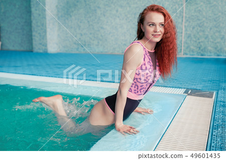 Beautiful young woman in the indoor swimming pool. Beautiful young woman in the indoor swimming pool. 49601435