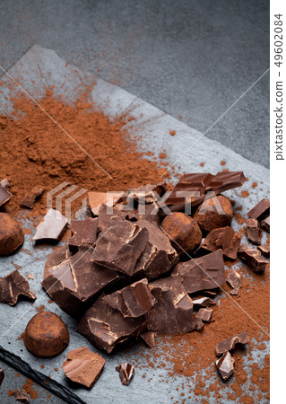 Dark or milk organic chocolate pieces on dark concrete backgound 49602084