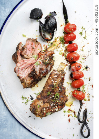 Barbecue leg of lamb and a tomato skewer  49602819