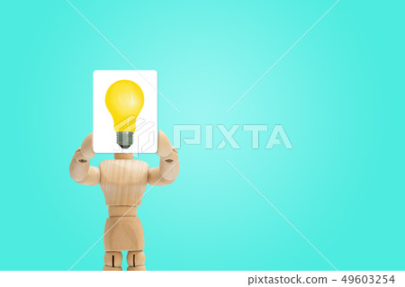 Wooden figure holding yellow light bulb. Wooden figure holding yellow light bulb. 49603254