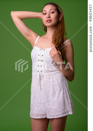 Young beautiful Asian woman against green background Young beautiful Asian woman against green background 49603457