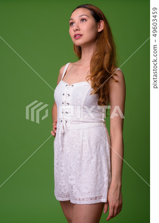 Young beautiful Asian woman against green background Young beautiful Asian woman against green background 49603459