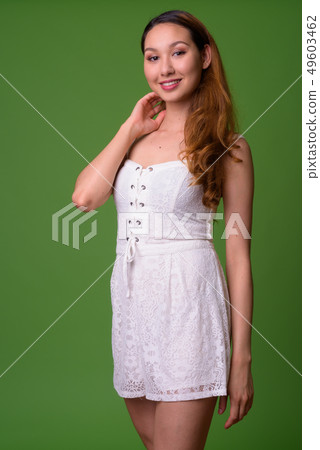 Young beautiful Asian woman against green background Young beautiful Asian woman against green background 49603462