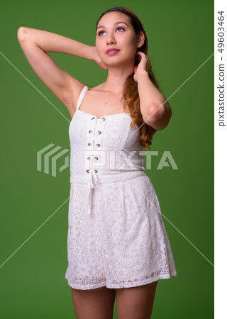 Young beautiful Asian woman against green background 49603464