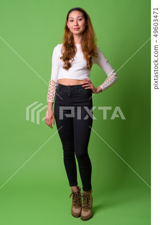 Young beautiful Asian woman against green background Young beautiful Asian woman against green background 49603471