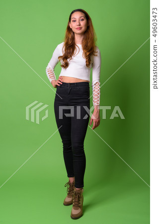 Young beautiful Asian woman against green background Young beautiful Asian woman against green background 49603473