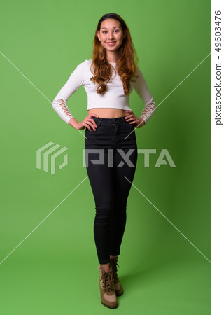 Young beautiful Asian woman against green background Young beautiful Asian woman against green background 49603476