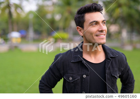 Face of happy young handsome Hispanic man thinking at the park 49605160