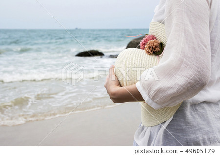Woman holding hat on the beach 49605179