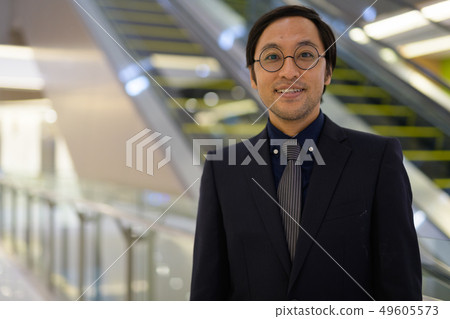 Face of happy Asian businessman smiling inside the office building Face of happy Asian businessman smiling inside the office building 49605573
