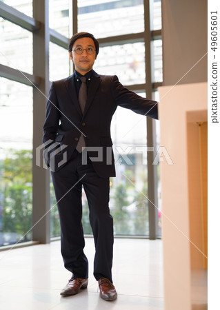 Full body shot of Asian businessman thinking by the window 49605601