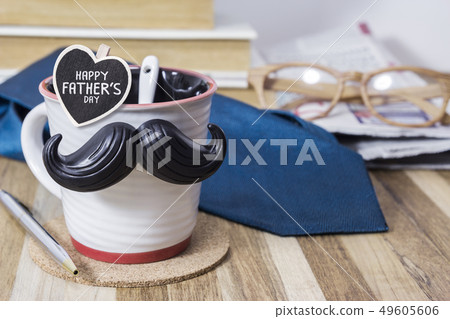Cup with mustache on wooden table for fathers day 49605606