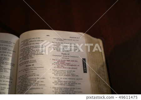 Open bible on a dark wood table Open bible on a dark wood table 49611475
