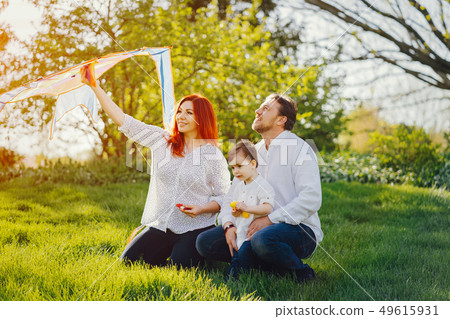 cute family sitting in a sunny park 49615931