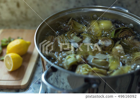 Cleaned artichokes cooking 49616092