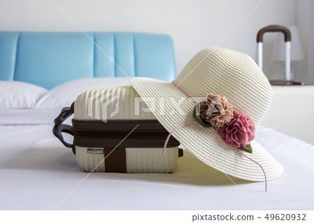 Hat and luggage on bed in the bedroom Hat and luggage on bed in the bedroom 49620932