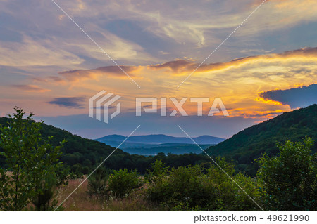 scenic sunset over the clouds between the green wo scenic sunset over the clouds between the green wo 49621990