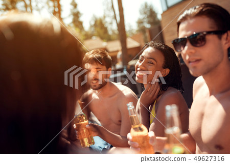 Young Friends with Alcoholic Drinks at Poolside 49627316