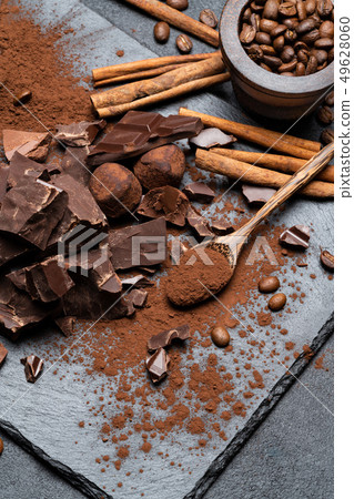 Dark or milk organic chocolate pieces and cocoa powder on dark concrete backgound Dark or milk organic chocolate pieces and cocoa powder on dark concrete backgound 49628060