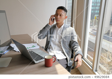 商人用他的手肘在他的胳膊上打電話 49629084