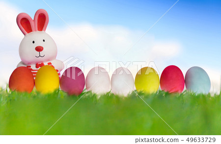 Easter rabbit with eggs on green grass under blue Easter rabbit with eggs on green grass under blue 49633729