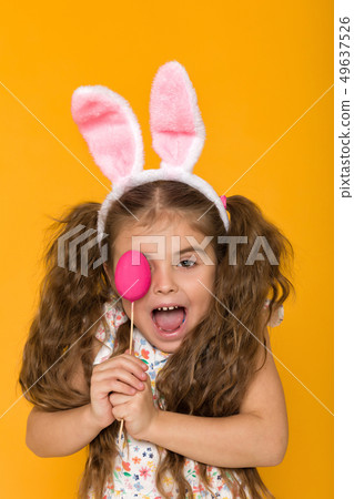 cute little girl with Easter bunny ears holding colorful eggs cute little girl with Easter bunny ears holding colorful eggs 49637526