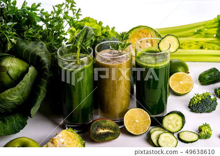 Different healthy vegan spinach, kiwi and cucumber drinks on the white wooden background. Raw drinks 49638610