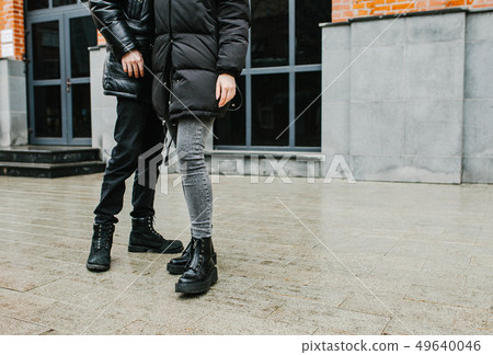 a guy and a girl stand next to each other on the street. 49640046