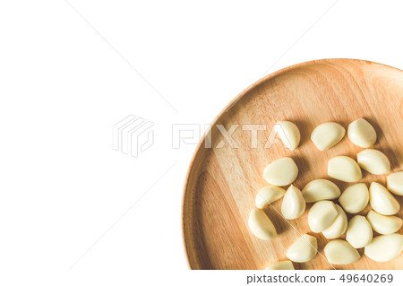 Garlic cloves on round wooden plate isolated Garlic cloves on round wooden plate isolated 49640269